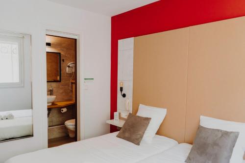 凯恩L'Hôtel Bristol的卧室配有白色的床和红色的墙壁