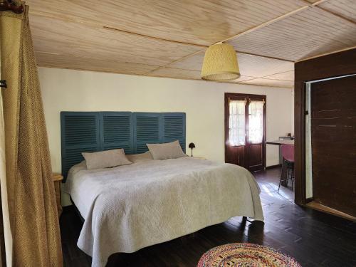 圣何塞德迈波Cabaña Jacuzzi Interior的一间卧室配有一张大床和蓝色床头板