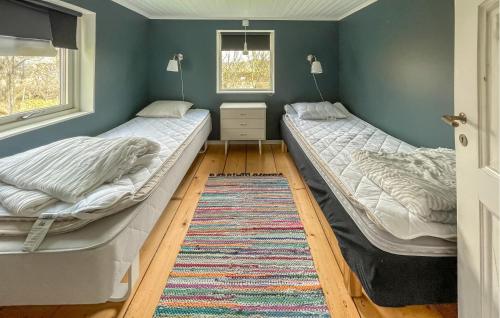 瓦尔贝里3 Bedroom Lovely Home In Varberg的配有地毯的客房内的两张床