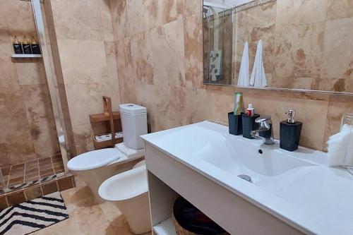 罗安达Moody & cozy 1br in city center的浴室配有白色水槽和卫生间。