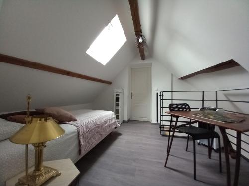 蒙特里夏尔gite de la tour carrée的一间卧室配有一张床、一张桌子和一个窗户。