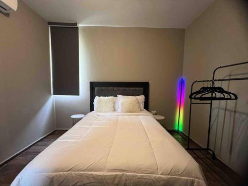 比亚埃尔莫萨Departamento de lujo Torre Pólvora Residencial的一间卧室配有一张大白色床和彩虹灯