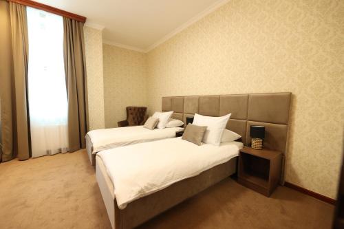 巴尼亚卢卡维多维奇酒店的酒店客房设有两张床和窗户。