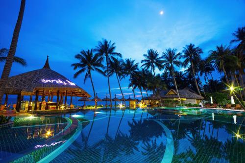 美奈美奈孟青假日酒店的棕榈树的夜间游泳池