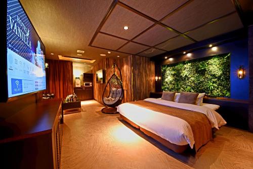 小牧市小牧香草情趣酒店（仅限成人）的一间卧室设有一张大床和一个大屏幕