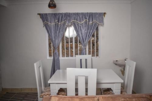 KiambuMella Homes Limuru的窗户客房内的桌椅