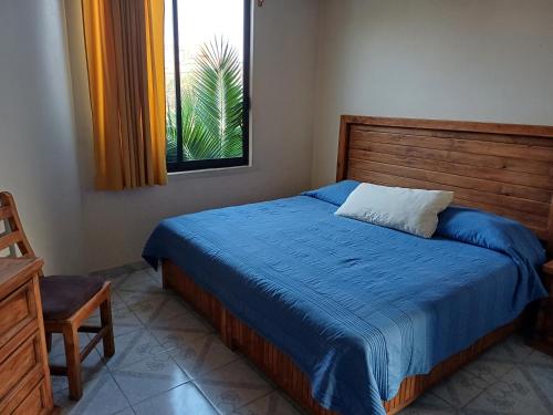 底拉斯卡拉Rústica Azul的一间卧室配有一张带蓝色毯子的床和窗户。
