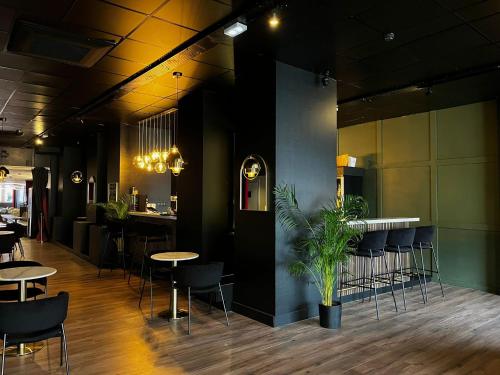 香槟沙隆HOTEL & SPA Le Renard Centre的一间带桌椅的餐厅和一间酒吧