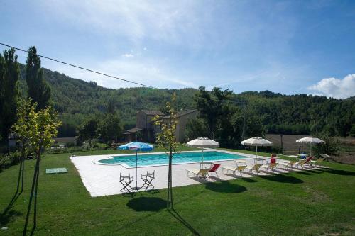 FermignanoAgriturismo Verziere的一个带椅子和遮阳伞的游泳池