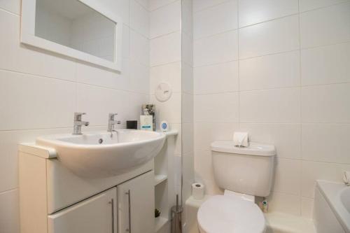 佩斯利2 bed flat near airport &parking的白色的浴室设有水槽和卫生间。
