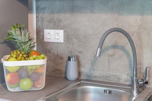 雅典The HostMaster Aethereal Style的厨房水槽里装有一篮水果