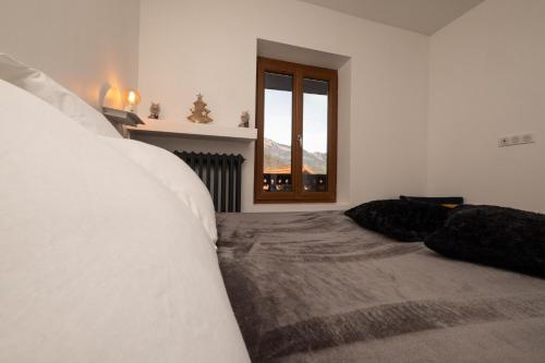 VenthonChalet les Myrtilles的白色的卧室设有床和窗户