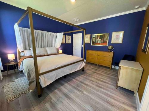 桑福德Sanford Long-term Stay的一间卧室设有天蓬床和蓝色的墙壁。