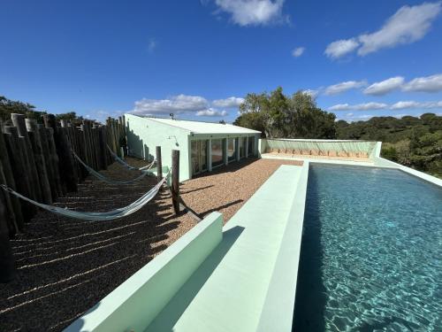 梅利迪什Cabanas de Melides的房屋旁带吊床的游泳池