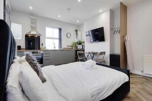 伯恩茅斯Wimbourne Road Apartment 1的一间带白色床的卧室和一间厨房