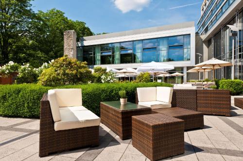 威斯巴登威斯巴登杜瑞特帕拉斯酒店的一座带两把椅子和一张桌子的庭院以及一座建筑
