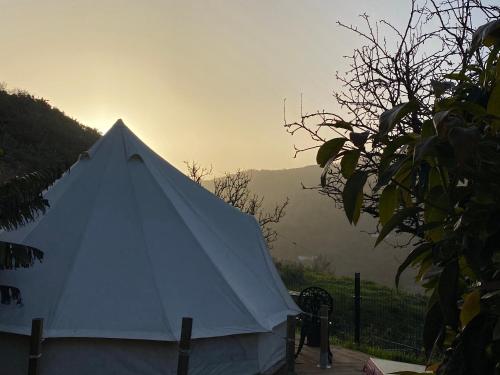 贝加德圣马特奥Angel Caves Farmstay的白色帐篷,背面是日落