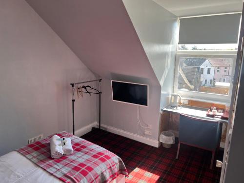 罗塞斯Gothenburg Hotel的一间卧室配有一张床、一张书桌和一个窗户。