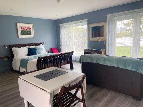 戈尔韦The Cosy Studio by the shore的一间拥有蓝色墙壁的卧室,配有一张床和一张桌子