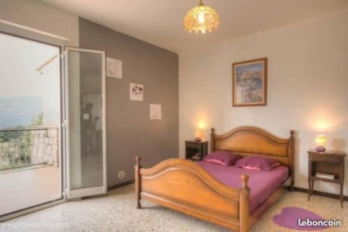 Ucciani95m2 au calme à 25mn AJACCIO, plages, linge inclus parking ok的一间带木床的卧室和一个阳台