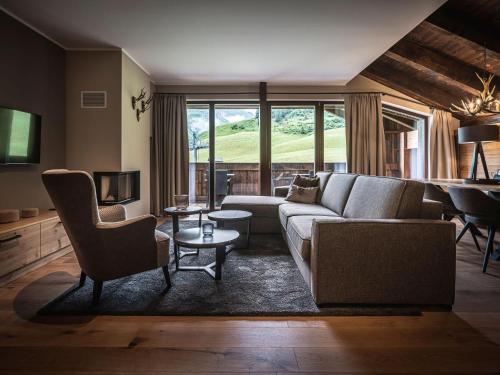 沃瑟姆阿尔伯格AlpenParks Hotel & Apartment Arlberg Warth mit Pool的客厅配有沙发、椅子和钢琴