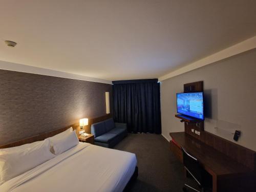 里斯本里斯本机场智选假日酒店的配有一张床和一台平面电视的酒店客房