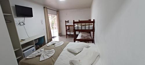 佩尼亚Pousada Casa Amarela Brisa Parque的一间卧室配有一张床、一张书桌和一台电视