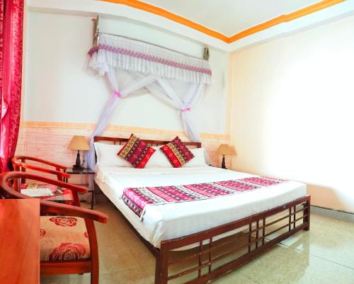 萨帕阮当住宿加早餐旅馆的一间卧室配有一张带红色窗帘的床和一扇窗户