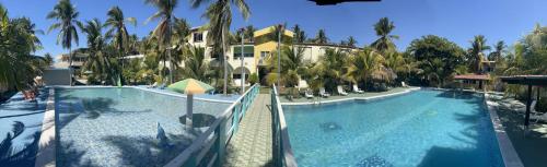 El ZapoteCoconut village的一座棕榈树建筑旁边的大型游泳池