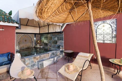 马拉喀什Riad Khadoj-Marrakech-Traditional的庭院设有壁炉、椅子和桌子