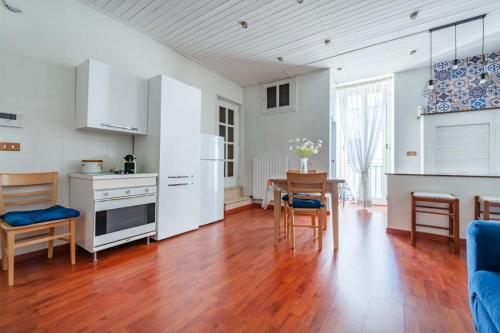 孔韦尔萨诺B&b SAN LORENZO的厨房配有白色橱柜和桌椅