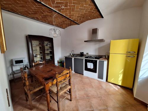 卡尔米尼亚诺弗里吉奥纳亚农家乐的厨房配有木桌和黄色冰箱。