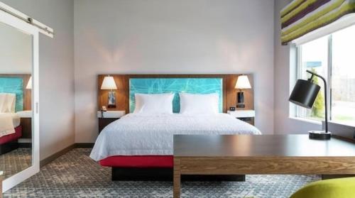 芝加哥Hampton Inn & Suites Chicago Medical District Uic的酒店客房设有一张带书桌的床和窗户。