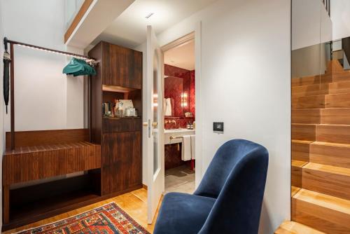 米兰Vico Milano的客厅设有蓝色椅子和楼梯