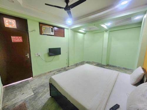 诺伊达Hotel AV Residency Sector 45 Noida的一间卧室设有一张床,另一扇门设有电视