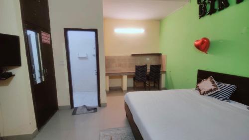 诺伊达Hotel AV Residency Sector 45 Noida的一间卧室配有一张床,另一间卧室配有桌子