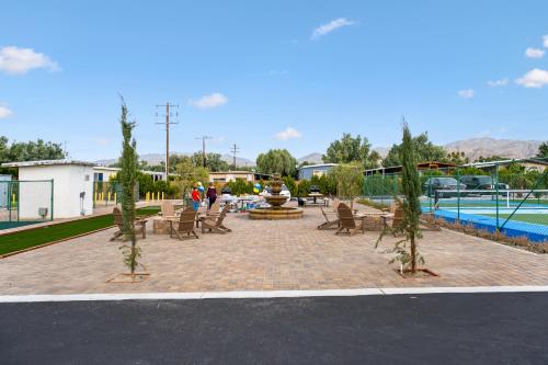 沙漠温泉RV71-Lot- Paradise RV Park的一个带椅子的庭院和一个游泳池旁的喷泉
