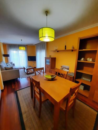 格罗韦Apartamento en Beiramar的用餐室以及带桌椅的起居室。
