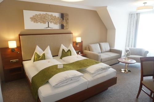 Eibiswald克鲁普菲客乐花园酒店的一间卧室配有一张床、一张沙发和一把椅子
