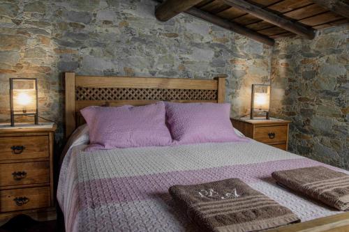 雷东多DieAna Alojamento Redondo的一间卧室配有一张带紫色床单的床和两盏灯。