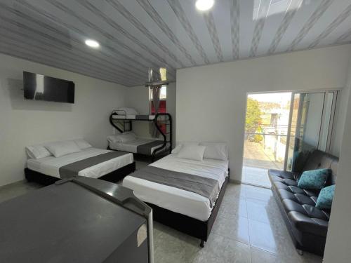 圣玛尔塔EL PARAISO DE GAIRA的一间客房配有两张床和一张沙发