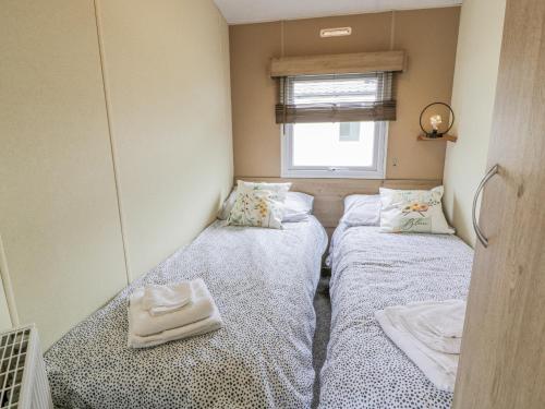 TarboltonMiddlemuir Retreat的小型客房设有两张单人床和窗户。