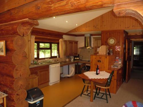 查尔德Tamarack Lodge的小屋内的厨房设有木墙和桌子