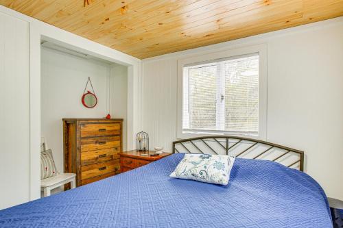 IronsCozy Wellston Cabin - Walk to Crystal Lake!的一间卧室配有一张蓝色的床和木制天花板