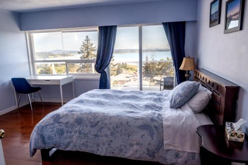 维多利亚HOV B&B House -Hospitality Ocean View Victoria-的一间卧室设有一张床和一个大窗户
