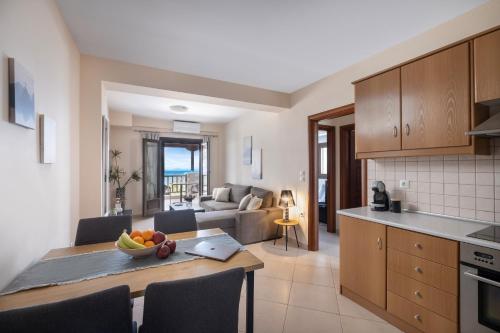 科罗皮Iakovakis Seaside Exclusive Apartments的厨房以及带一碗水果的桌子的客厅。