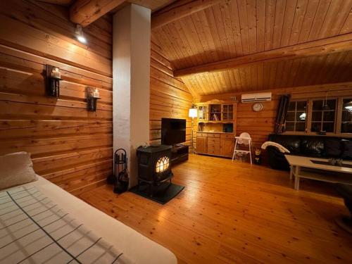 TornesTraditional Norwegian log cabin with sauna by the sea的一间带壁炉的卧室,位于带木墙的房间内