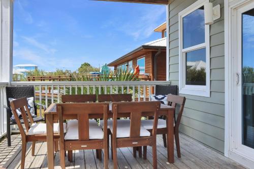 Cape San BlasSearenity by Pristine Properties Vacation Rentals的房屋甲板上的木桌和椅子