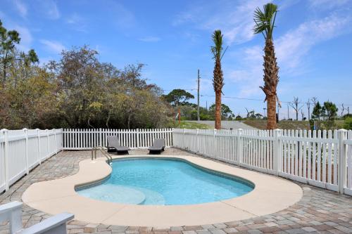 Cape San BlasSearenity by Pristine Properties Vacation Rentals的一个带白色围栏和棕榈树的游泳池