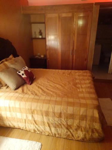 PantojaNido de Amor的一间卧室配有一张大床和木柜